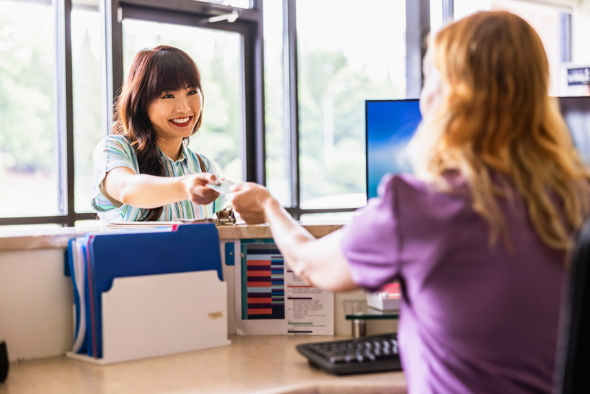 A woman being handed a card.