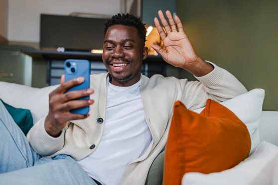 A man waving at a phone.