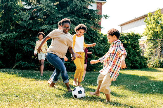 Niños jugando al fútbol en un patio trasero.